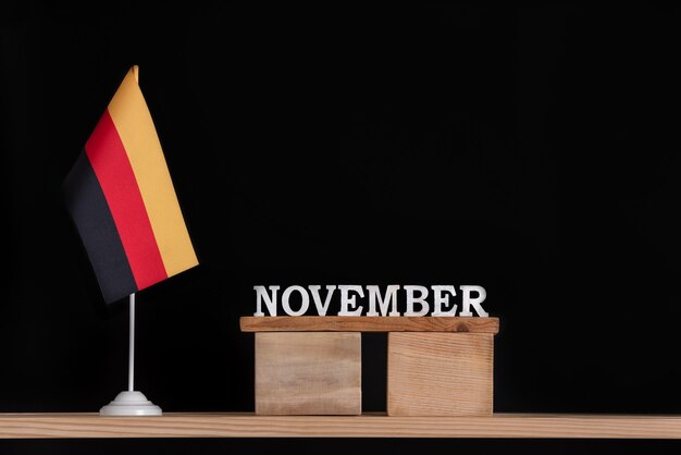 Wooden calendar of November with German flag on black background. Dates in Germany in November.