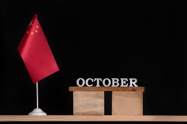 Wooden calendar of October with Chinese flag on black background Holidays of China in October