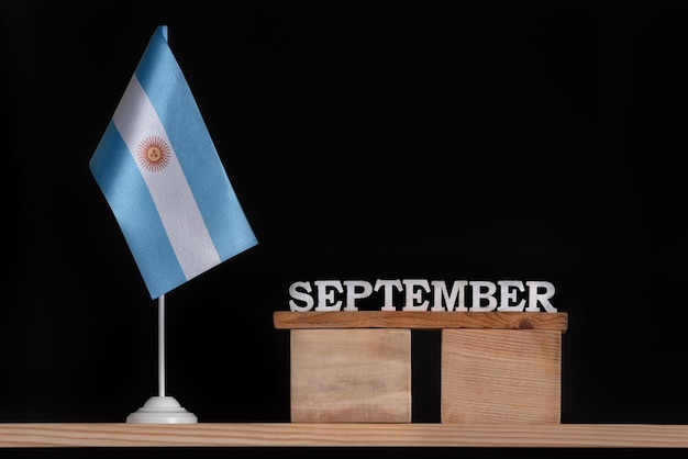 Wooden calendar of September with Argentine flag on black background Holidays of Argentina in September