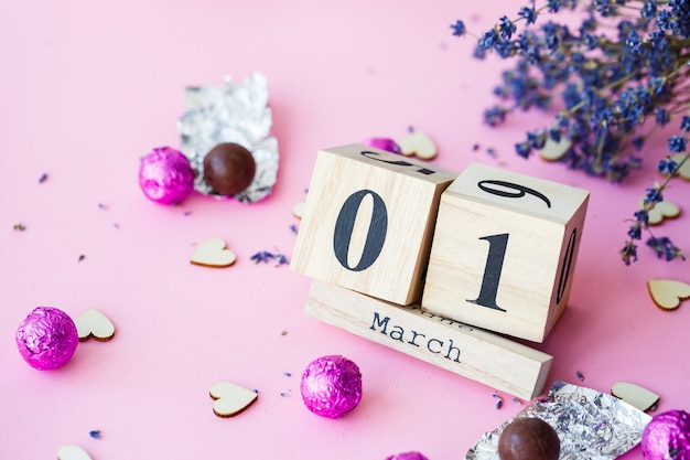 Wooden calendar with the date of March 1 on a pink background, a place for an inscription, The first day of spring, a dry branch of lavender