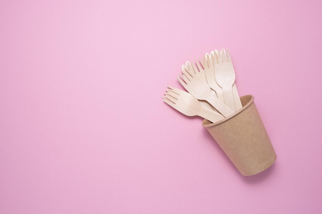 Wooden and cardboard disposable tableware on a gray background. Environmentally friendly products.