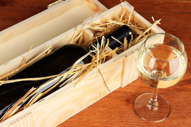 Wooden case with wine bottle on table