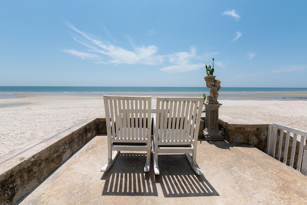 Wooden chair on coastline with blue sky in tropical sea