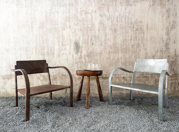 The wooden chair and metal chair with the small table in the garden