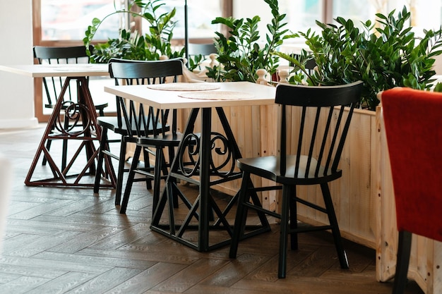 Wooden chairs in an empty cafe during pandemic No guests Served table