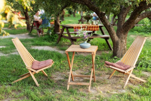 Wooden chairs and table table in summer orchard. Wooden outdoor furniture set for Picnic in garden