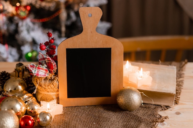 A wooden chalkboard with a christmas tree in the background