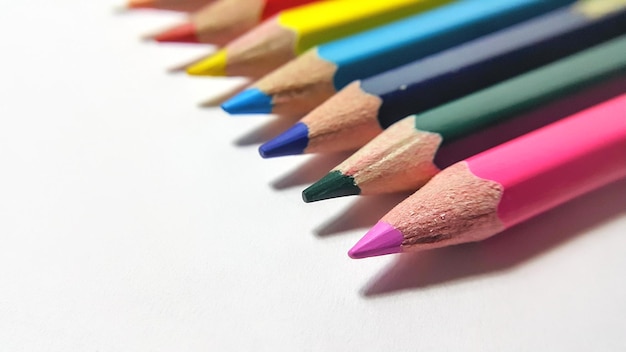 Wooden color pencils arranged in bulk on a white isolated background