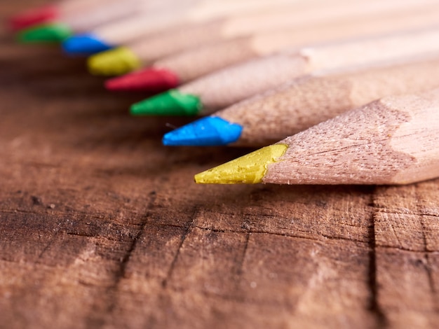 Wooden color pencils on display on a row, on a wooden table, education and school concept