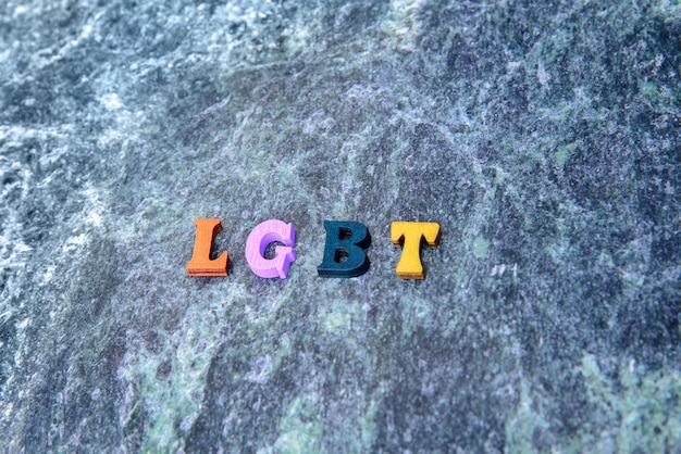 Photo wooden colored letters lgbt on a blue marble background