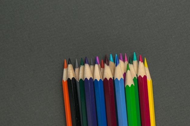 Wooden colored pencils on a gray background