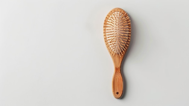 Photo a wooden comb is on a white surface with a wooden handle