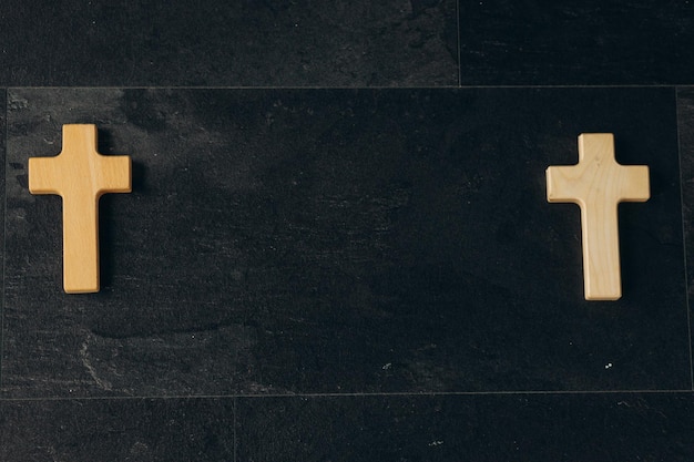 Wooden cross on a new black plastered brick wall Concept of Religion Banner