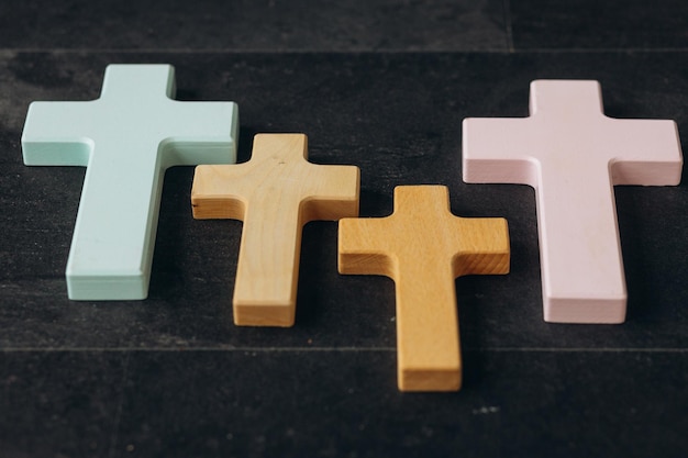 Wooden cross on a new black plastered brick wall Concept of Religion Many crosses