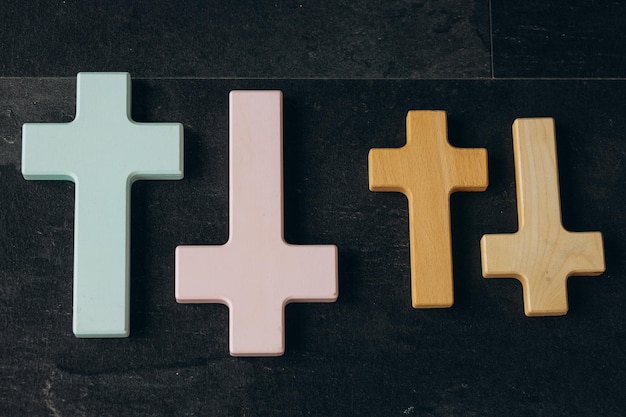 Wooden cross on a new black plastered brick wall Concept of Religion