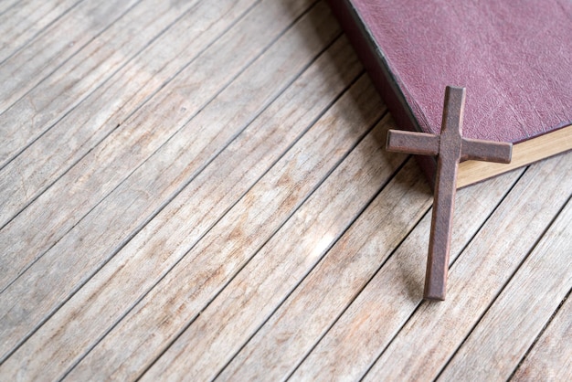 Wooden cross on top of a leather cover bible