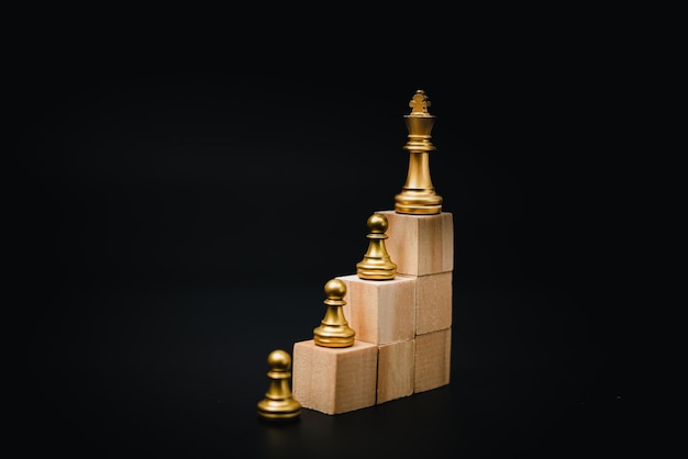 Wooden cube and chess business and marketing strategy concept in planning goals on black background