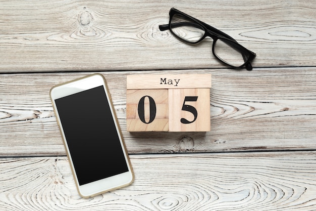 wooden cube shape calendar for MAY 5 on wooden table