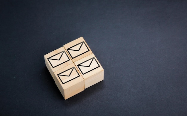 wooden cube with four email icons the concept of email to or business through email