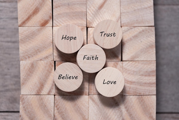 Wooden cube with inspirational text Faith trust believe hope and love Beautiful wooden table background Business and Faith concept Copy space