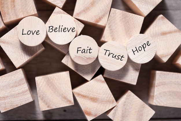 Wooden cube with inspirational text Faith trust believe hope and love Beautiful wooden table background Business and Faith concept Copy space