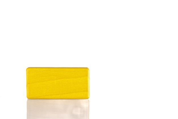 Wooden cube of yellow color on a white background