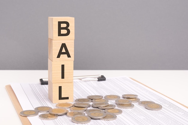 wooden cubes forming the text BAIL surrounded by coins symbolize a structured plan and financial framework for achieving freedom from debt or financial challenges