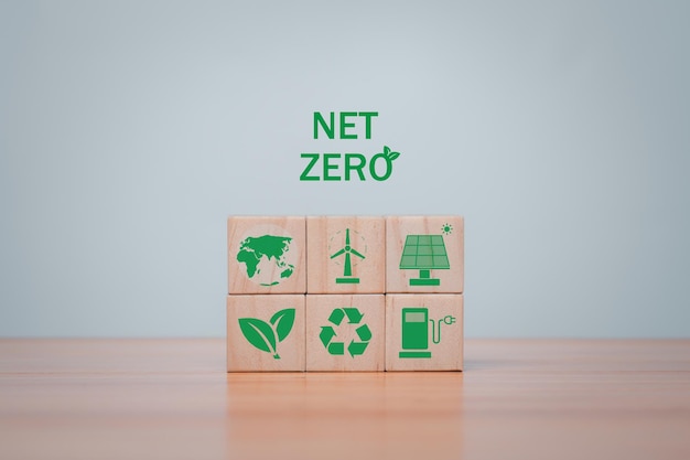 Wooden cubes with green net zero icon and green icon on grey background Net zero and carbon neutral concept plastic free earth day world environment day