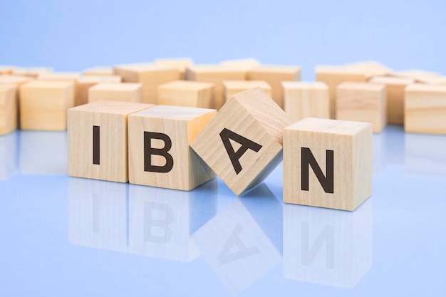 Wooden cubes with the letters IBAN on the bright surface of a pale lilac table the inscription on the cubes is reflected from the surface of the table business concept