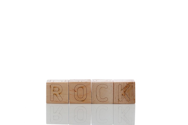 Wooden cubes with letters rock on a white background