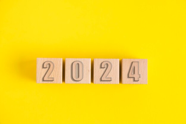 Wooden cubes with numbers 2024 yellow background