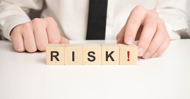 Wooden cubes with the text RISK on a light blue wooden background