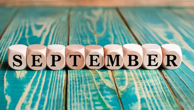 Wooden cubes with text SEPTEMBER on greenturquoise wood surface Month of year Autumn season