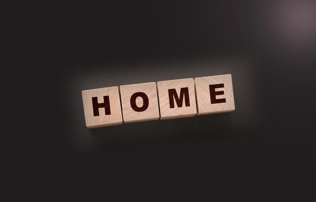 Wooden cubes with the word home home on a black background Real estate business or Emigration consept