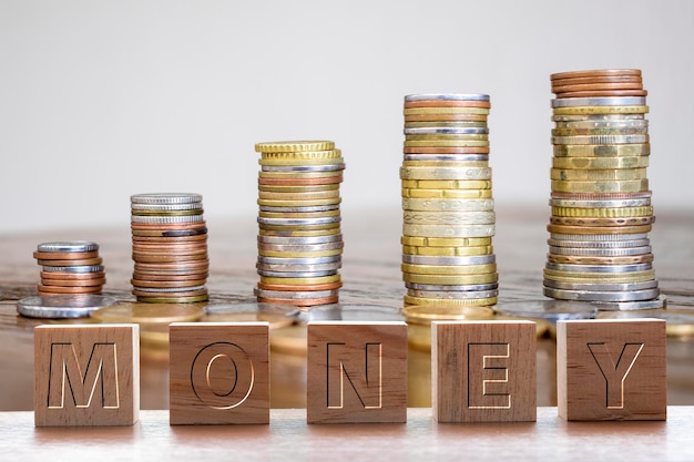 Wooden cubes with the word money with coin stack background