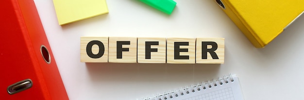 Wooden cubes with word OFFER on the office desk