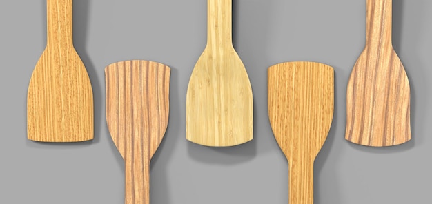 Wooden culinary spatulas for cooking food isolated on grey background 3d render top view Realistic bamboo kitchen tool set natural eco friendly kitchenware made of wood utensils