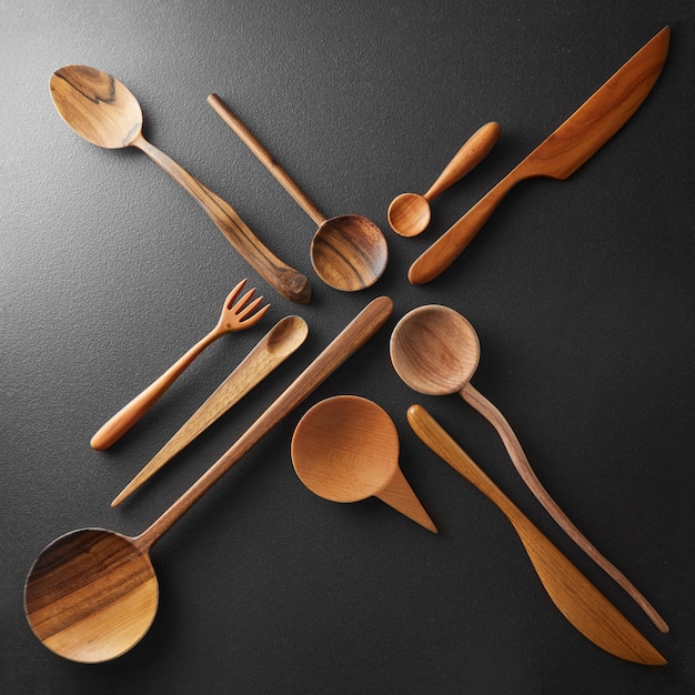 Wooden cutlery in the form of a cross on a black background isolated