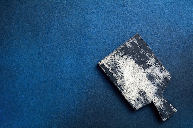 Wooden cutting board on a dark blue background Kitchenware top view Empty space for your ready meals