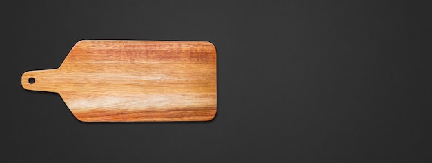 Wooden cutting board isolated on black background. Horizontal banner