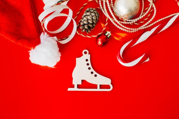 Wooden decoration on the Christmas tree in the form of a figure skate on a red background.