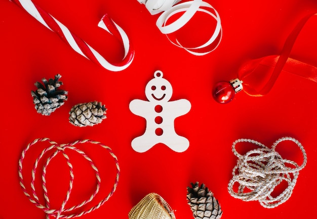 Wooden decoration on the Christmas tree in the form of gingerbread man surrounded by Christmas elements