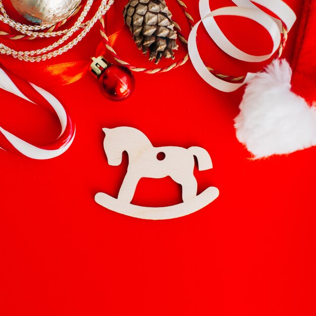 Wooden decoration on the Christmas tree in the form of rocking horses surrounded by Christmas elements. 