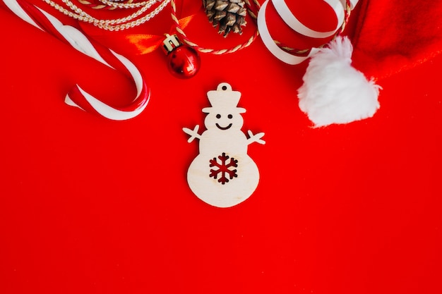 Wooden decoration on the Christmas tree in the form of a snowman on red 