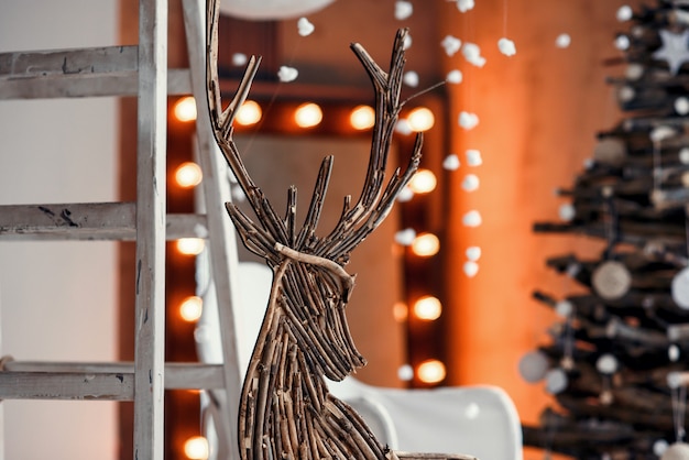 Wooden decorative deer close up. Modern Christmas interior decorated in rustic style.