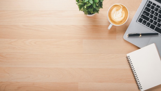 Photo wooden desk workplace with laptop computer notebook pen and cup of coffee top view flat lay with copy space