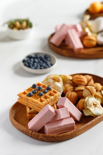 Wooden dish with sweets waffles and pastilles Natural sweets Apple chips