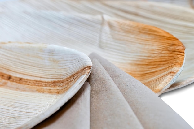 Wooden disposable tableware with plates and napkins for picnic on the white background.