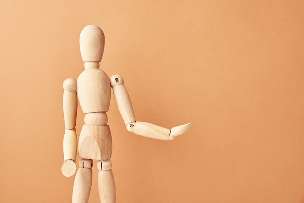 Wooden doll on beige background