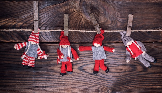 Wooden dolls in winter clothes hang on a rope